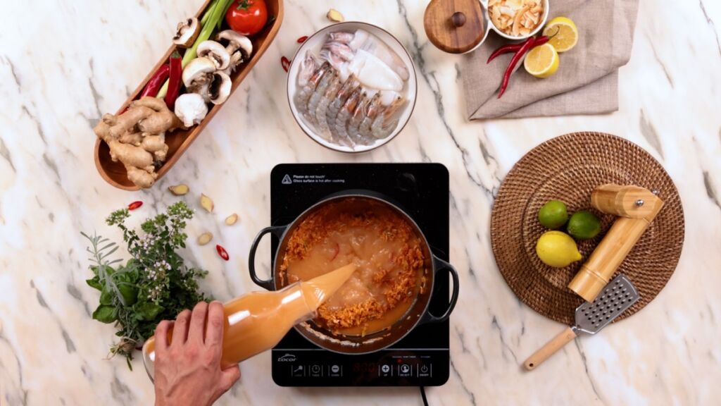 Junte o Arroz agulha e 750ml do Caldo de Camarão feito anteriormente e mexa continuamente para aumentar a cremosidade do arroz.
