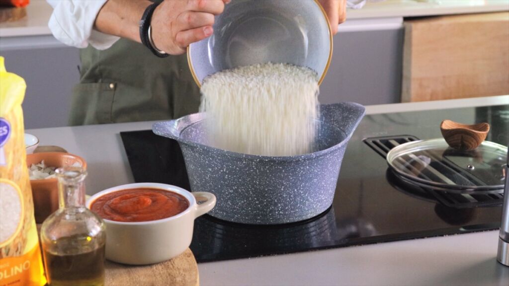 De seguida junte o arroz e envolva, regue com o caldo, mexa e tape.