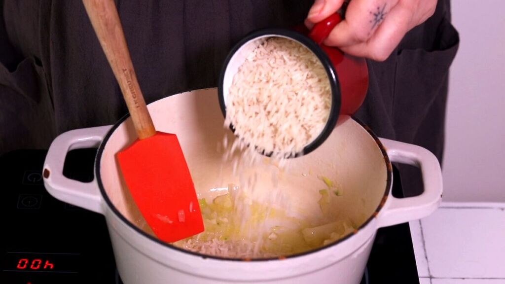 De seguida, junte o arroz ao tacho, envolva bem no refogado e mexa constantemente durante cerca de 1-2 minutos.