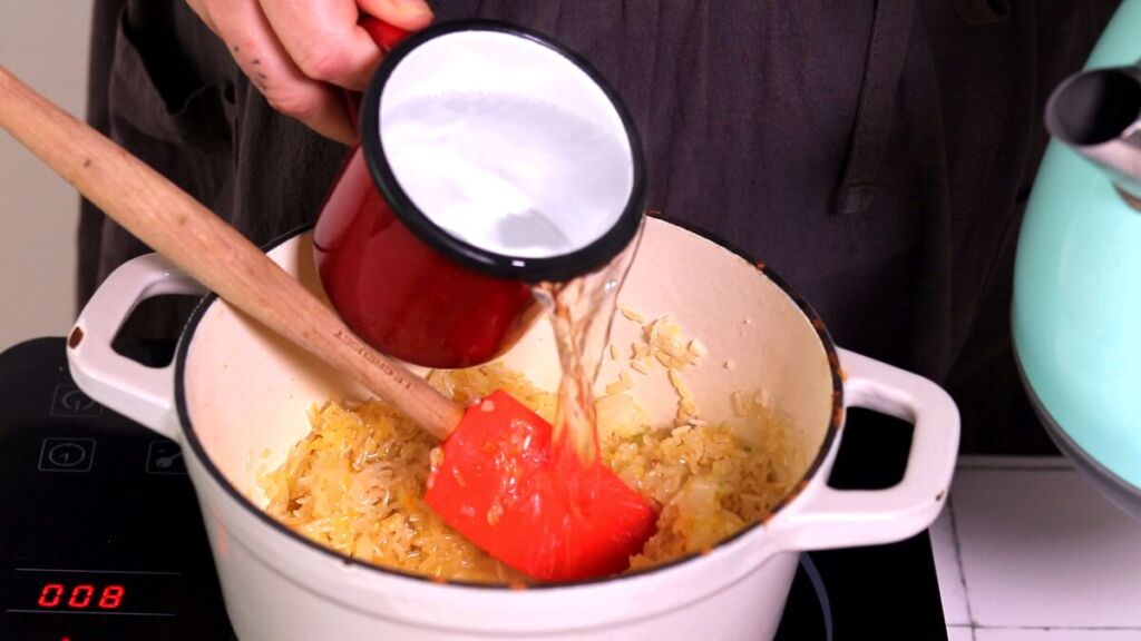 Finalmente, junte a água a ferver ao arroz temperado.